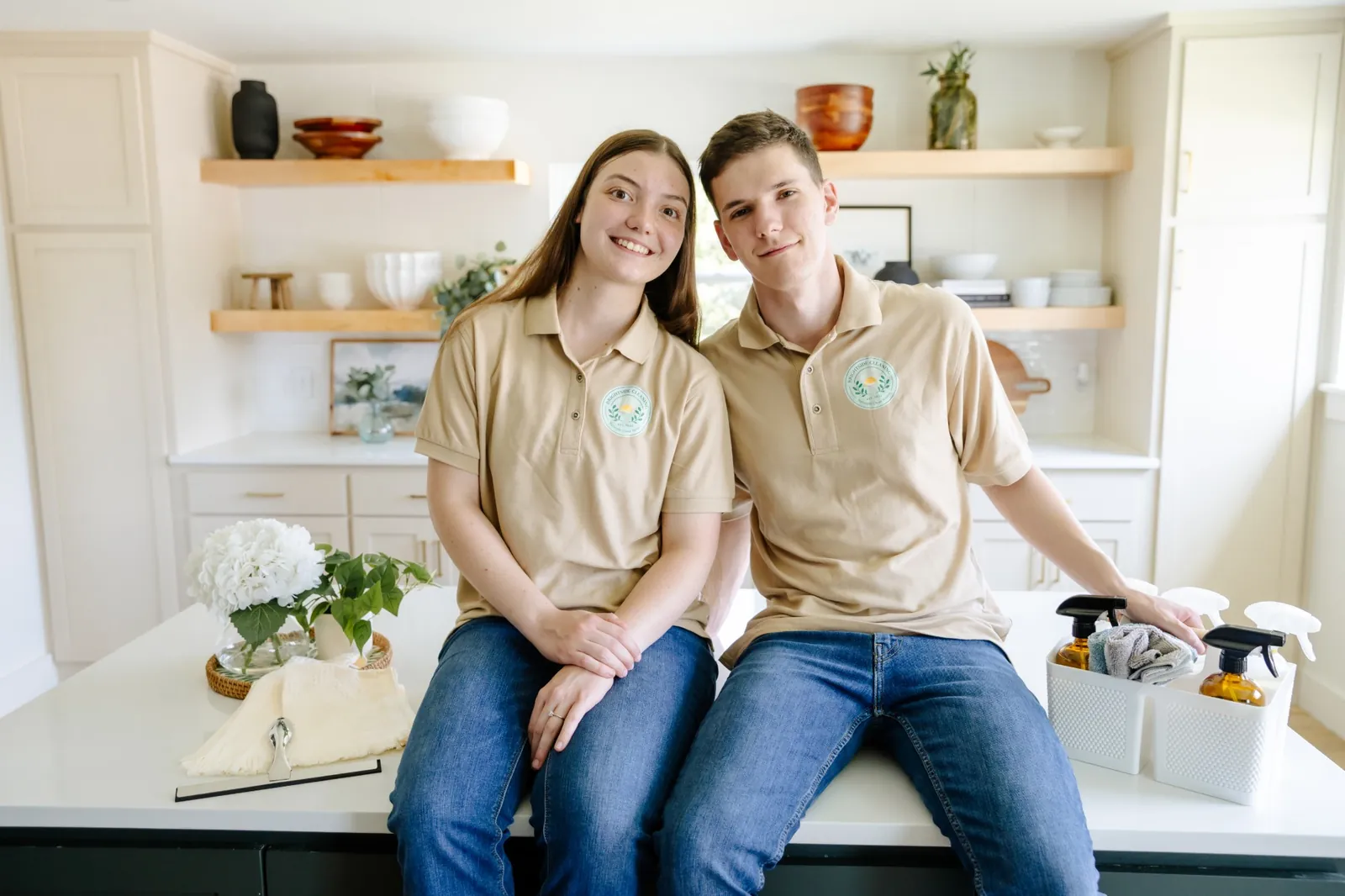 Ethan and Lauren Kern of Brightside Cleaning NWA in uniform with their natural cleaning supplies